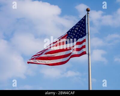 Amerikanische Flagge am Pol gegen bewölkten und blauen Himmel Stockfoto