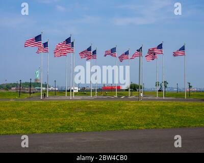 Blick auf die Freiheitsstatue in Amerika vom Liberty State Park Jersey City New Jersey hinter amerikanischen Flaggen Stockfoto