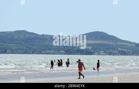 Menschen am Portmarnock Beach, Dublin, während das warme Wetter anhält. Bilddatum: Freitag, 29. Mai 2020. Das trockene, sonnige Wetter wird sich über das Juni-Feiertagswochenende fortsetzen, wobei die Temperaturen in einigen Gebieten auf 25 Grad Celsius steigen werden. Siehe PA Geschichte WETTER Sonne Irland. Das Foto sollte lauten: Brian Lawless/PA Wire Stockfoto