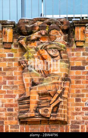 Eine Reliefskulptur aus Ziegelsteinen, die den Verrat an der Nordwand des RSC Shakespeare Theatre in Stratford-upon-Avon, England, darstellt Stockfoto