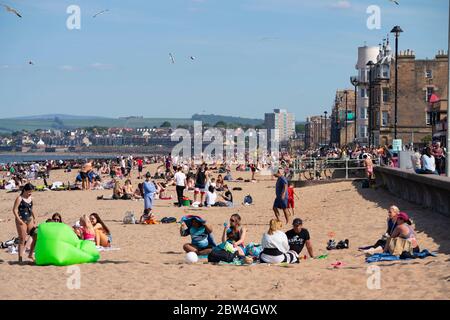 Portobello, Schottland, Großbritannien. 29 Mai 2020. Sonnenschein und Temperaturen von 23 C am Strand und an der Promenade von Portobello brachten Menschenmassen ins Freie. Die von der schottischen Regierung gestern angekündigte Lockdown-Regelung für Covid-19 erlaubt es der Öffentlichkeit, sich zu sonnen. Iain Masterton/Alamy Live News Stockfoto