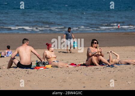 Portobello, Schottland, Großbritannien. 29 Mai 2020. Sonnenschein und Temperaturen von 23 C am Strand und an der Promenade von Portobello brachten Menschenmassen ins Freie. Die von der schottischen Regierung gestern angekündigte Lockdown-Regelung für Covid-19 erlaubt es der Öffentlichkeit, sich zu sonnen. Iain Masterton/Alamy Live News Stockfoto