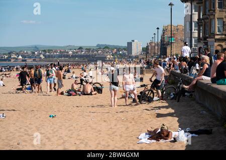 Portobello, Schottland, Großbritannien. 29 Mai 2020. Sonnenschein und Temperaturen von 23 C am Strand und an der Promenade von Portobello brachten Menschenmassen ins Freie. Die von der schottischen Regierung gestern angekündigte Lockdown-Regelung für Covid-19 erlaubt es der Öffentlichkeit, sich zu sonnen. Iain Masterton/Alamy Live News Stockfoto