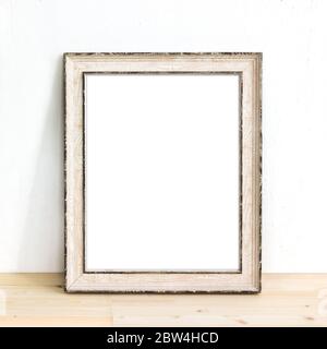 Rustikaler Bilderrahmen aus Holz, der auf einem Tisch steht. Produktmodell Stockfoto