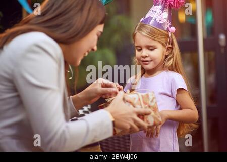 Mutter feiern glückliches Kind Mädchen Geburtstag und Geschenke. Stockfoto