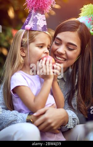 Happy Birthday Mädchen feiern Geburtstag und aß Apfel mit ihrer Mutter. Stockfoto