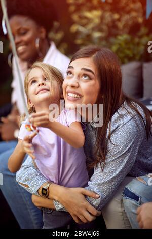 Nettes Mädchen und ihre Mutter spielen mit Ballon.Kids feiern Geburtstag. Stockfoto