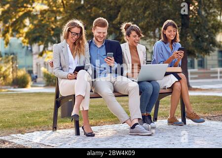 Eine Gruppe von Kollegen trifft sich an einem sonnigen Tag in einem Park Stockfoto