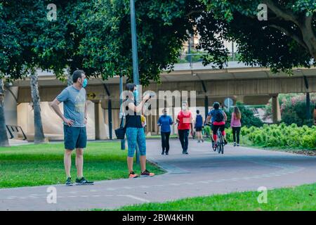 Valencia, Spanien - 28, Mai 2020: Ein Paar mit chirurgischen Gesichtsmasken, die im Park fotografieren. Neuer Normalzustand während COVID-19, Coronavirus-Pandemie. Sozial Stockfoto