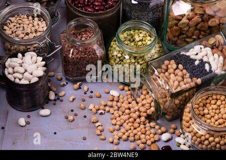 Große Auswahl an getrockneten Hülsenfrüchten in Gläsern. Hintergrund Textur mit Draufsicht Stockfoto