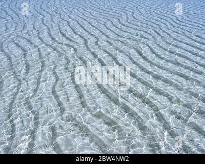 Kristallklares Wasser und Wellen in einem weißen Korallensandboden, in einem tropischen Cotal Atoll, Indischer Ozean. Stockfoto