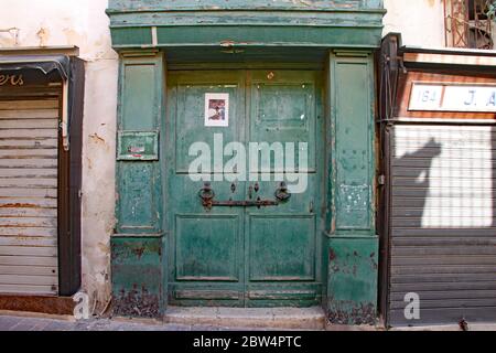 Alte grüne Tür in einem veröden Laden in Sliema, Malta Stockfoto