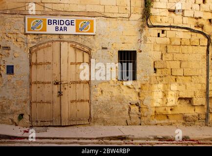 Alte und veraltete Türen in einer zerbröckelnden Kalksteinwand in Sliema, Malta Stockfoto
