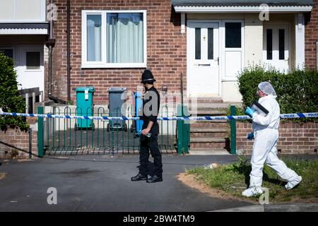 Manchester, Großbritannien. Mai 2020. Ein Gerichtsbeamter und die Polizei bleiben am Tatort auf der Greenwood Road. Kredit: Andy Barton/Alamy Live News Stockfoto