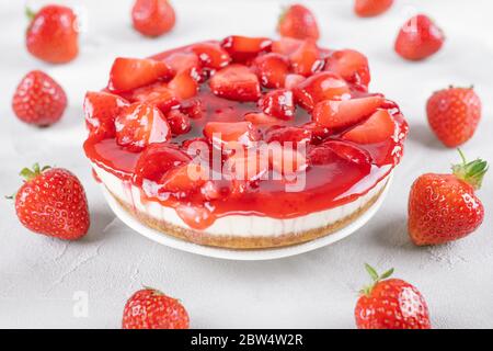 Käsekuchen mit Erdbeere und frischen Beeren auf grauem Tisch Stockfoto