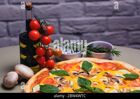 Leckere vegetarische Pizza mit Pilzen, Zucchini, Tomaten, Pfeffer und Basilikum Stockfoto