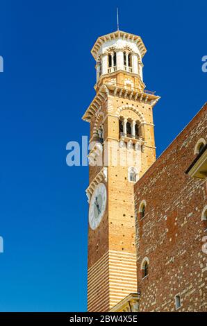 Torre dei Lamberti Uhrturm des Palazzo della Ragione Palastgebäude in Piazza Delle Erbe Platz in Verona City historischen Zentrum, vertikale Ansicht, blauer Himmel Hintergrund, Region Venetien, Italien Stockfoto