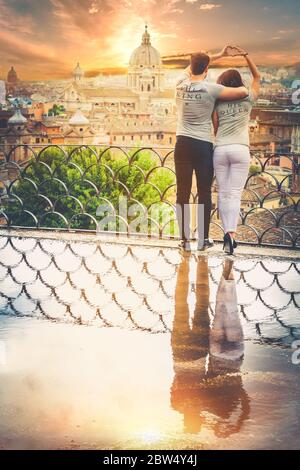 Schöne Paar Umarmung auf einer Terrasse mit einem Spiegelbild in einer Pfütze. Hinter ihnen die historische und antike Stadt Rom, Italien. Liebe, leidenschaftliche Affäre Stockfoto
