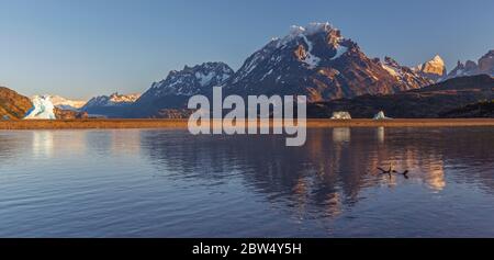 Panorama des Lago Grey bei Sonnenaufgang mit Eisberg und Spiegelung Cuernos del Paine, Nationalpark Torres del Paine, Patagonien, Chile. Stockfoto