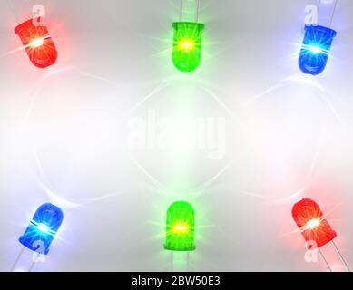Glänzende RGB-LEDs, die ätzendes Licht auf einem diffusen weißen Hintergrund ausgeben Stockfoto