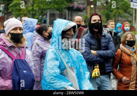 Investoren von Wohnkomplexen tragen Gesichtsmasken vor dem Kiewer Rathaus versammeln, wie sie an der Demonstration teilnehmen.etwa tausend Investoren der Bau Wohnanlagen, die in Wohnungen von Arkada Bank investiert blockiert die zentrale Straße Chreschatyk in Kiew und verbrannt Flares während ihres Protests gegen die Suspendierte Bau ihrer investierten Häuser, wie lokale Medien berichteten. Die Demonstranten fordern den Wiederaufbauvorgang der Wohnanlagen. Stockfoto