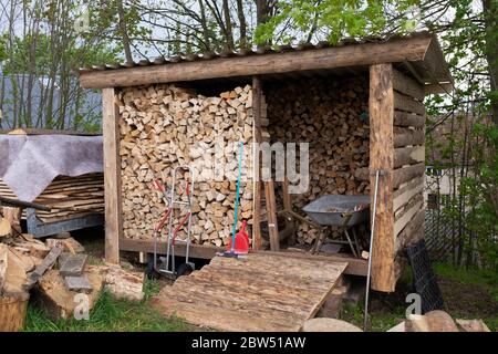 Brennholz in einem DIY Lagerschuppen im Garten Stockfoto