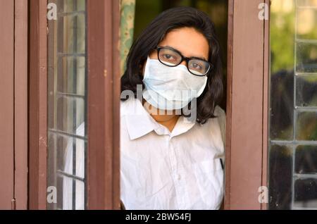 Besorgte und besorgte Dame unter der Sperre nach Hause Quarantäne Tragen schützende Atmung chirurgische Gesichtsmaske gegen Grippe und neuartige Corona-Virus (Covid-19) Stockfoto