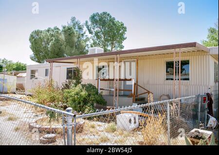 Anhänger in der Notwendigkeit von Reparaturen mit überwucherten Unkraut und viel Müll in den Hof - Mobile Home Investment - Cash-Renditen - Low Income Housing Stockfoto