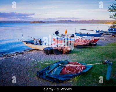 Eine Reihe von typischen Fischerbooten legte am Marta-Strand an, einem kleinen mittelalterlichen Dorf am Bolsena-Seeufer, Provinz Viterbo, Latium, Italien Stockfoto