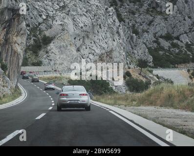 Mehrere Alfa Romeos in perfekter Linie fahren zusammen als Teil eines Enthusiasten-Events in Kroatien. Silber 159 im Fokus, Fahren auf Makarska riviera Stockfoto