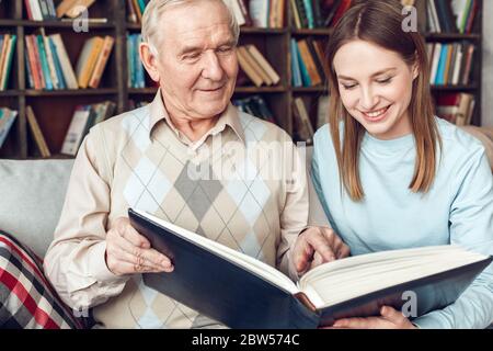 Vater und Tochter zu Hause Bibliothek sitzen Buch lesen zusammen glücklich Stockfoto