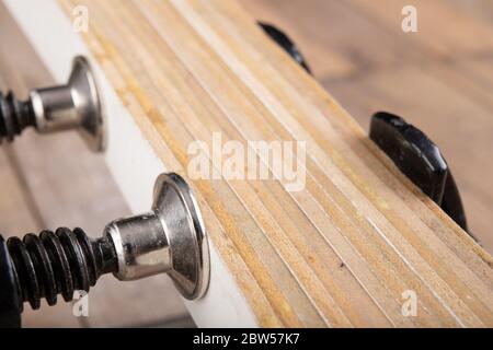 Schreinereiklemme zum Kleben von Holz. Kleine Zimmerei in einer Hauswerkstatt. Heller Hintergrund. Stockfoto