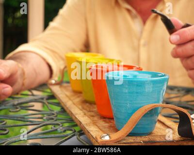 Freundliche Diskussion bei Kaffee, Hintergrund über einen Mann, der eine Pfeife hält Stockfoto