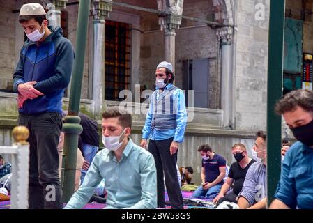 Beten mit medizinischen Masken vor der Blauen Moschee. Am ersten Freitag beten, namaz nach der Sperre in Istanbul. Muslime beten gemeinsam für Heilung Stockfoto