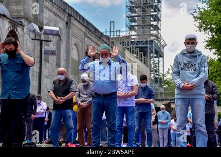 Beten mit medizinischen Masken vor der Blauen Moschee. Am ersten Freitag beten, namaz nach der Sperre in Istanbul. Muslime beten gemeinsam für Heilung Stockfoto
