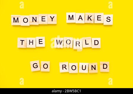 Sprichwörter Geld lässt die Welt auf gelbem Hintergrund umhergehen. Stockfoto