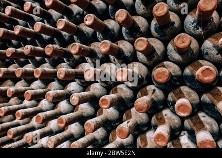 Alte Weinflaschen stapelten sich im alten Weinkeller Nahaufnahme Hintergrund Stockfoto