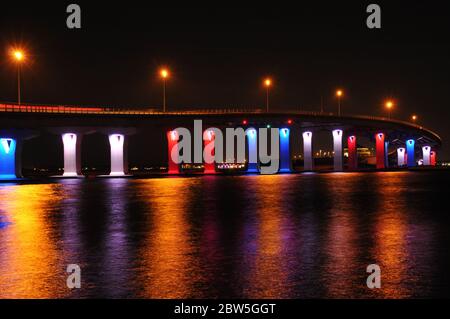 Ein farbenfrohes Nachtbild der Brücke, die in Rot, Weiß und Blau hell erleuchtet ist. Stockfoto