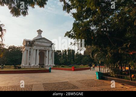 Die Sonne geht hinter einem griechisch-römischen Bogen im Zentrum des Bharathi Parks, Pondicherry, Indien, unter Stockfoto