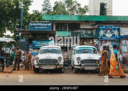 Zwei weiße Hindustan Ambassador Autos parkten am Straßenrand in Thanjavur, Indien Stockfoto