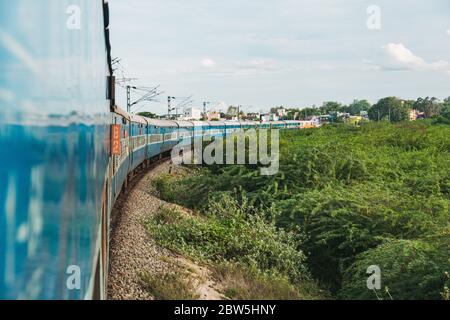 Der Blick auf die Wagen von der Zugtür, wie es eine Kurve nähert Madurai, Tamil Nadu, Indien Stockfoto