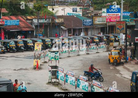 Eine Reihe von Auto-Rikschas warten auf Fahrpreise auf der Hauptstraße in Munnar Township, Kerala, Indien Stockfoto