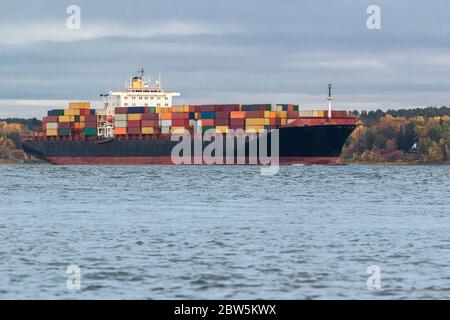 Container Frachtschiff Kreuzfahrt in der Nähe eines Hauses entlang des Flusses Stockfoto