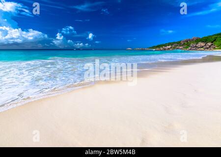 Weißer Sandstrand und türkisblaues Meer von Grand Anse mit Kopierplatz im Sand. Ruhige Tapete von tropischen Seychellen Strand, La Digue. Stockfoto