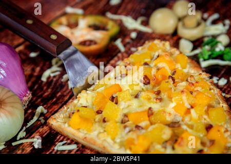 Nahaufnahme eines halben Stücks Pizza mit Ananas, Mango und heißen Würstchen mit Mozzarella-Käse Stockfoto