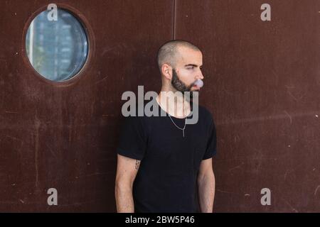 Tourist Mann rauchen gegen der rustikalen Wand. Reise- und Lifestyle-Konzept Stockfoto