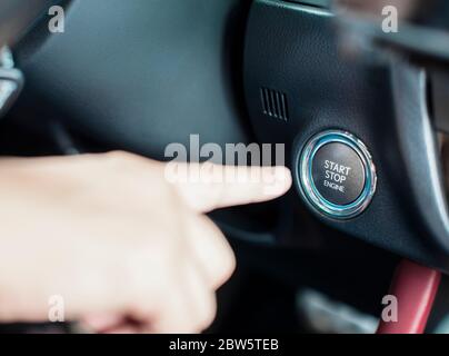 Finger und Motor Start Stopp-Taste im Auto Stockfoto