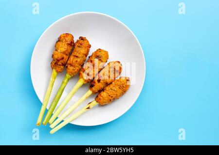 Gegrilltes Hackhuhn mit Currypaste und Kokosnusscreme auf den Spießen aus Zitronengras. Kopierbereich Stockfoto