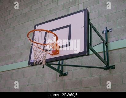 Basketballnetz und Brett gegen eine graue und grüne Backsteinwand Stockfoto