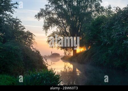 Kanalboot im Nebel auf dem oxford Kanal an einem Frühlingsmorgen bei Sonnenaufgang. In Der Nähe Von Somerton, Oxfordshire, England Stockfoto